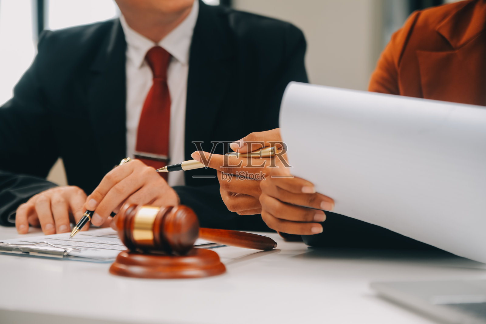 商务人士和律师们在办公室的桌子上用黄铜秤讨论合同文件。法律、法律服务、法律咨询、司法和法律概念图片具有膜纹效果照片摄影图片