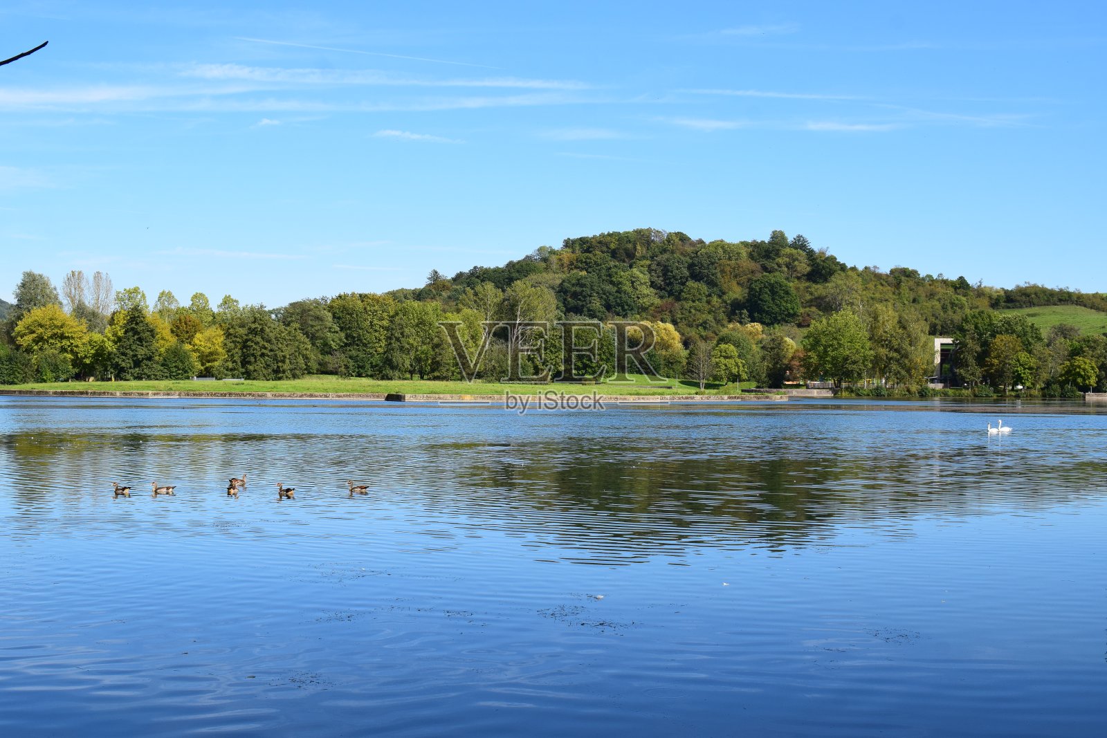 宽阔的蓝色湖泊和一座小山照片摄影图片