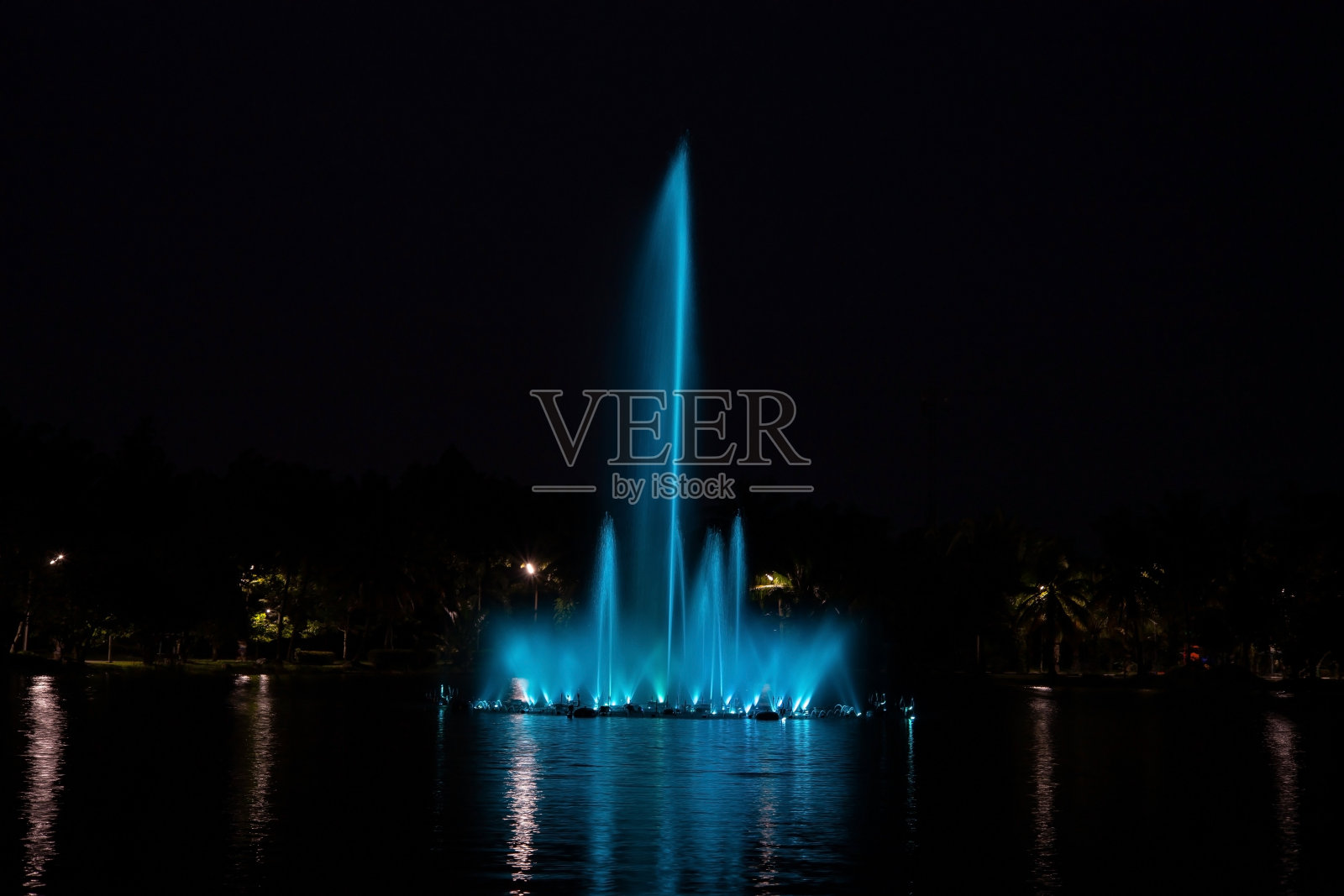 夜晚池塘里的蓝色喷泉照片摄影图片