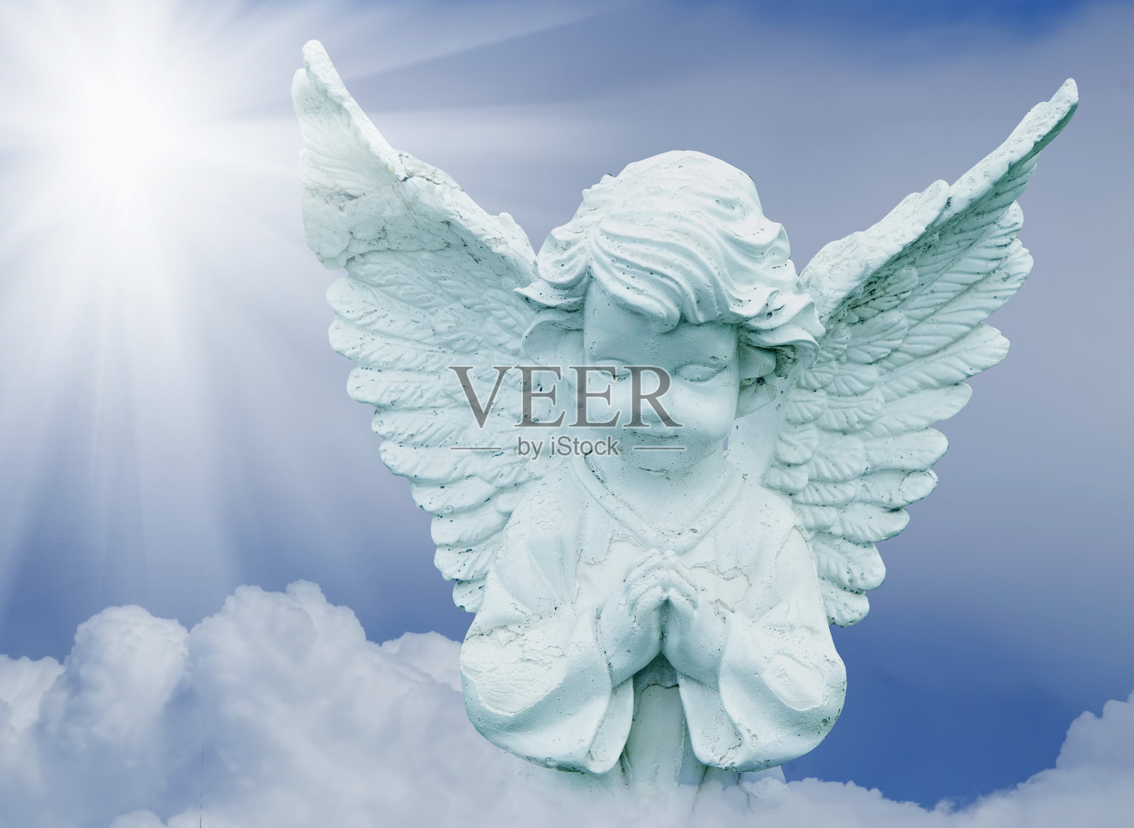 美丽的小天使在天空的一朵云上祈祷。照片摄影图片