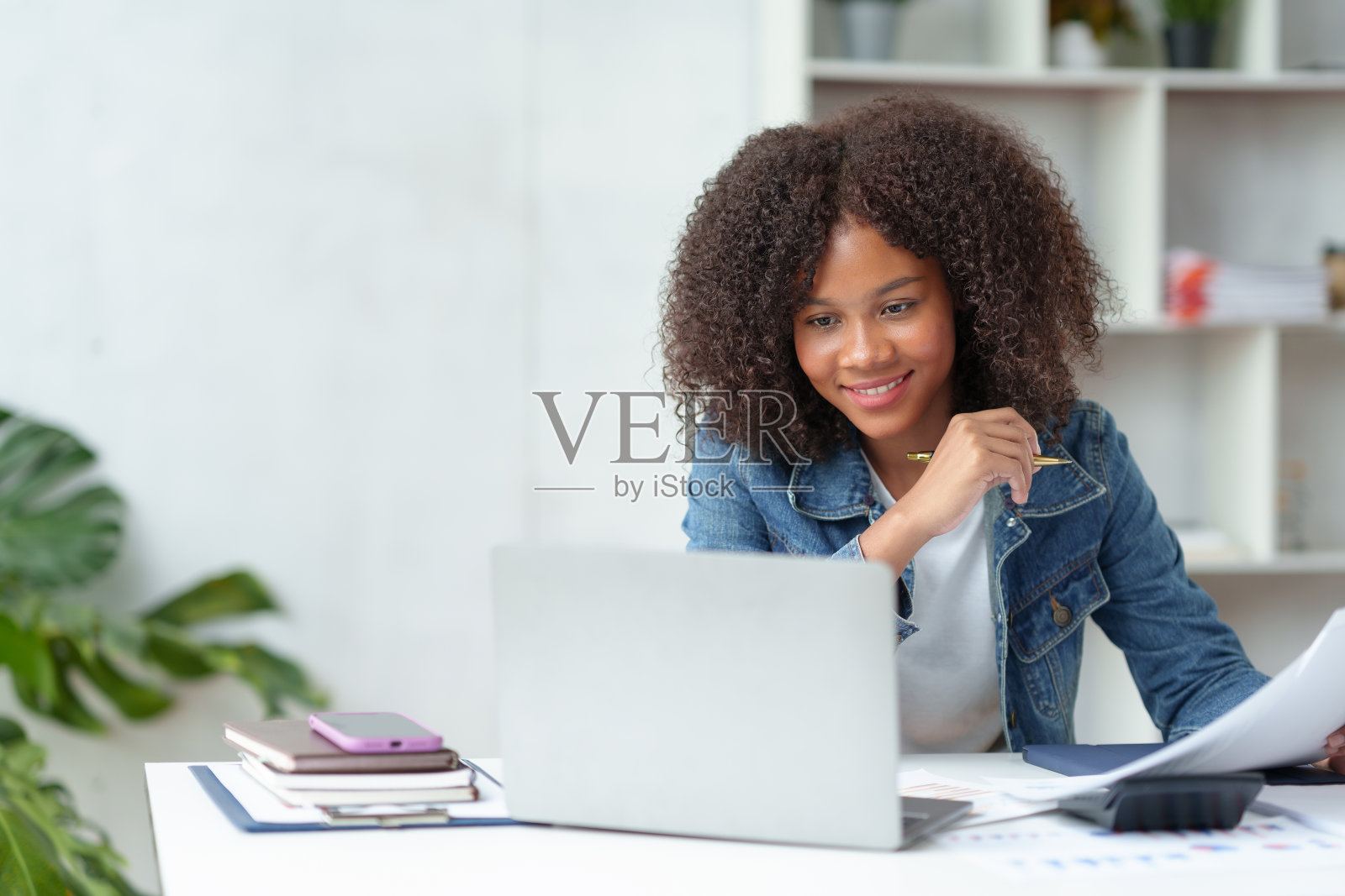 在线学习的美国美女学生在笔记本电脑上做笔记,收集她的工作笑脸和快乐的学习姿势。照片摄影图片