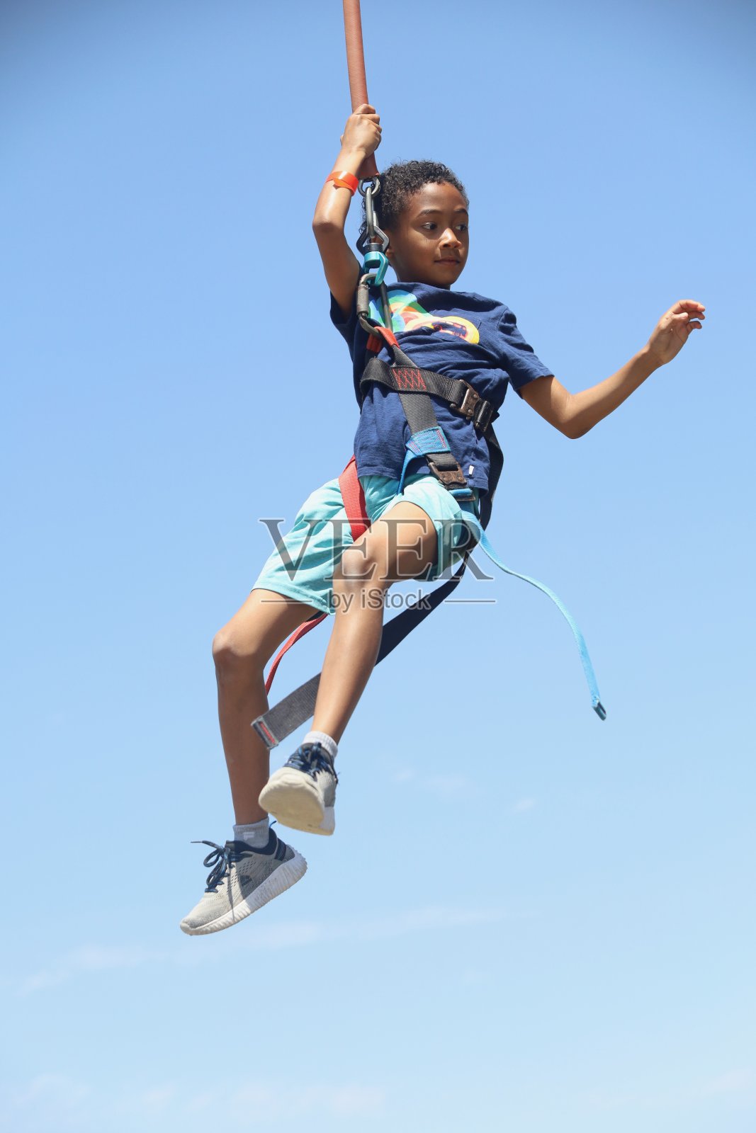 一个年轻人在天上用红线拴着绳子荡来荡去照片摄影图片