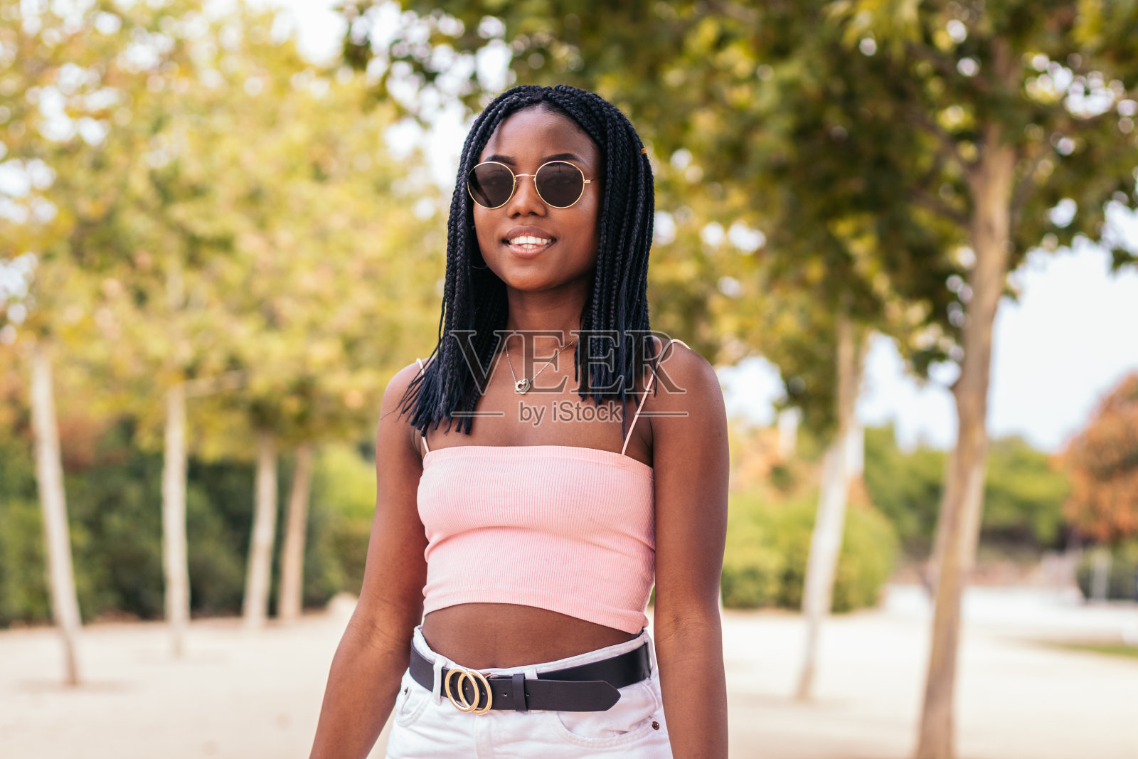 夏天公园里一个扎着辫子的非裔美国妇女的肖像照片摄影图片