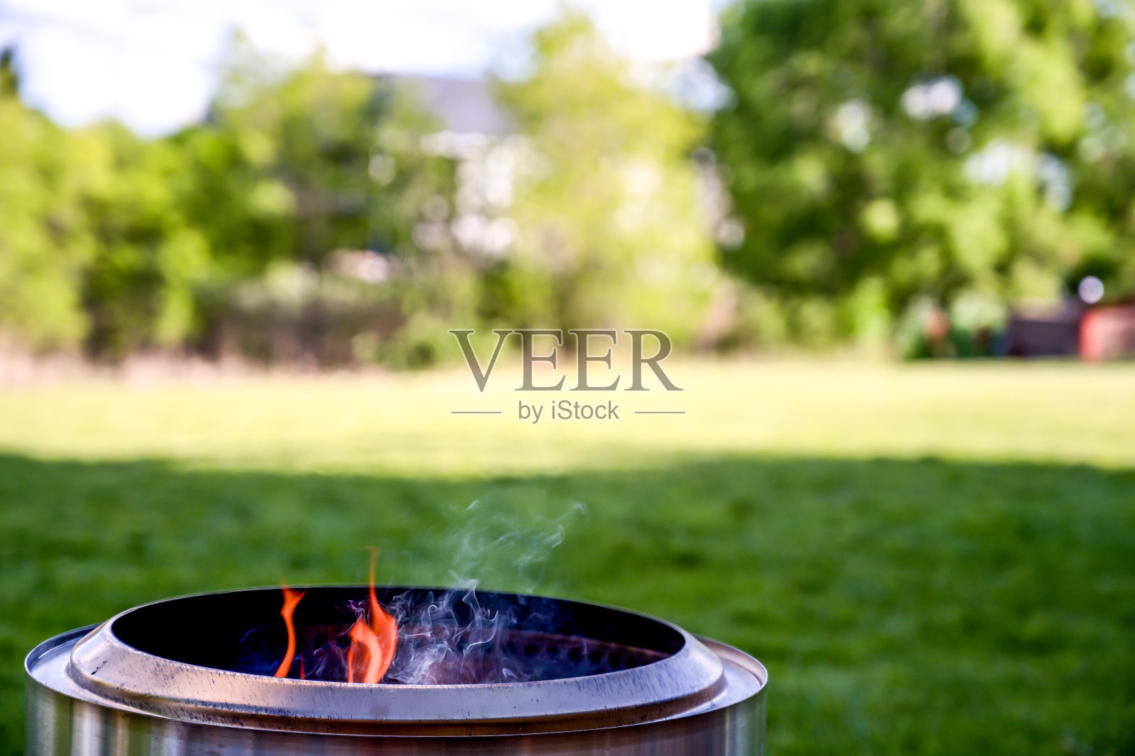 春天,住宅后院的无烟不锈钢火坑照片摄影图片