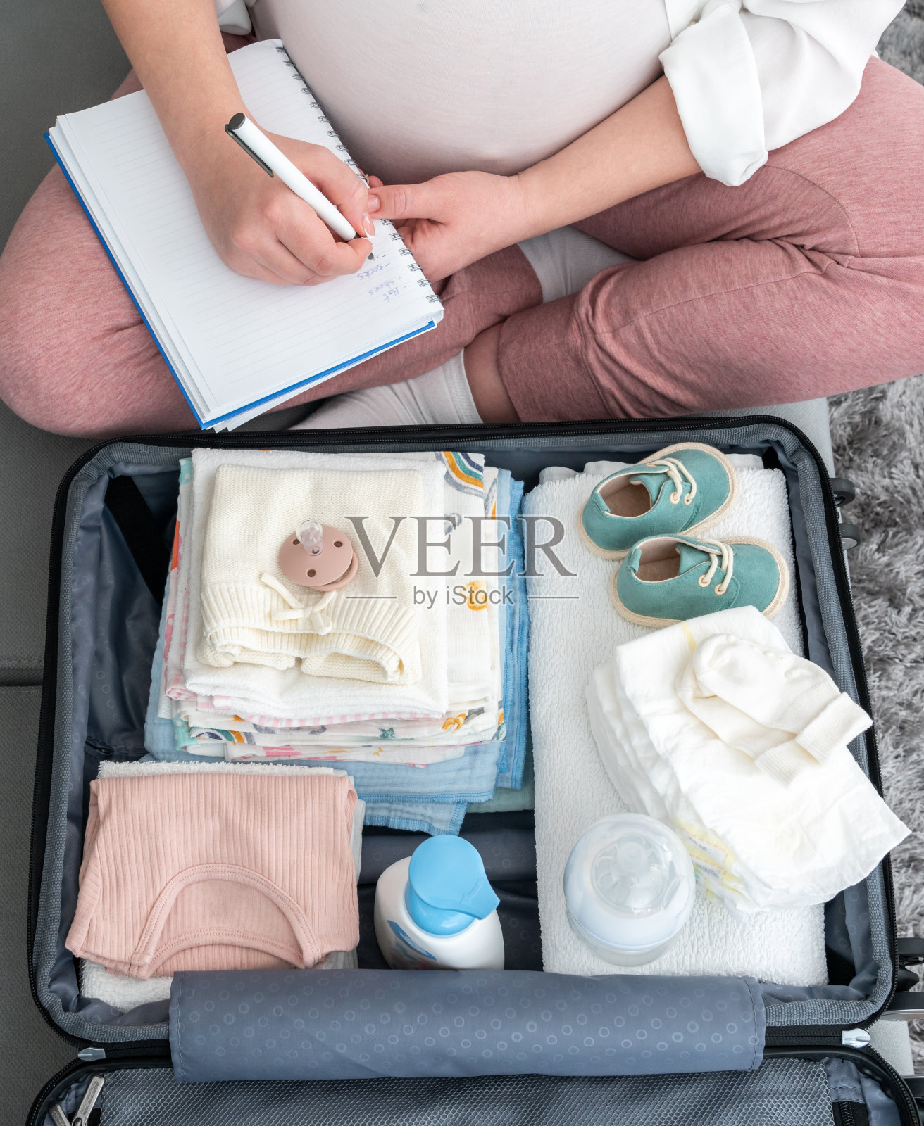 未来的母亲沉思着,坐在家里,一边收拾行李,一边记下必需品,准备去妇产医院照片摄影图片