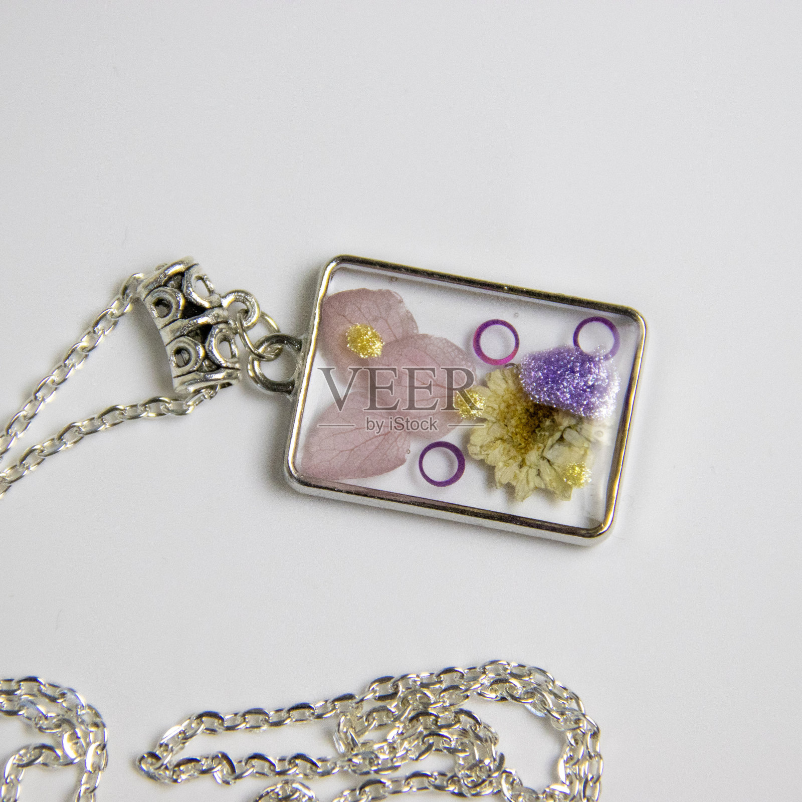 用环氧树脂和天然花朵制作的DIY服装首饰,DIY首饰大师。美丽的耳环和吊坠在家里制作的珠宝树脂。照片摄影图片