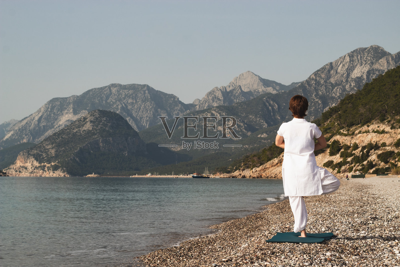 在沙滩上练习树式瑜伽照片摄影图片