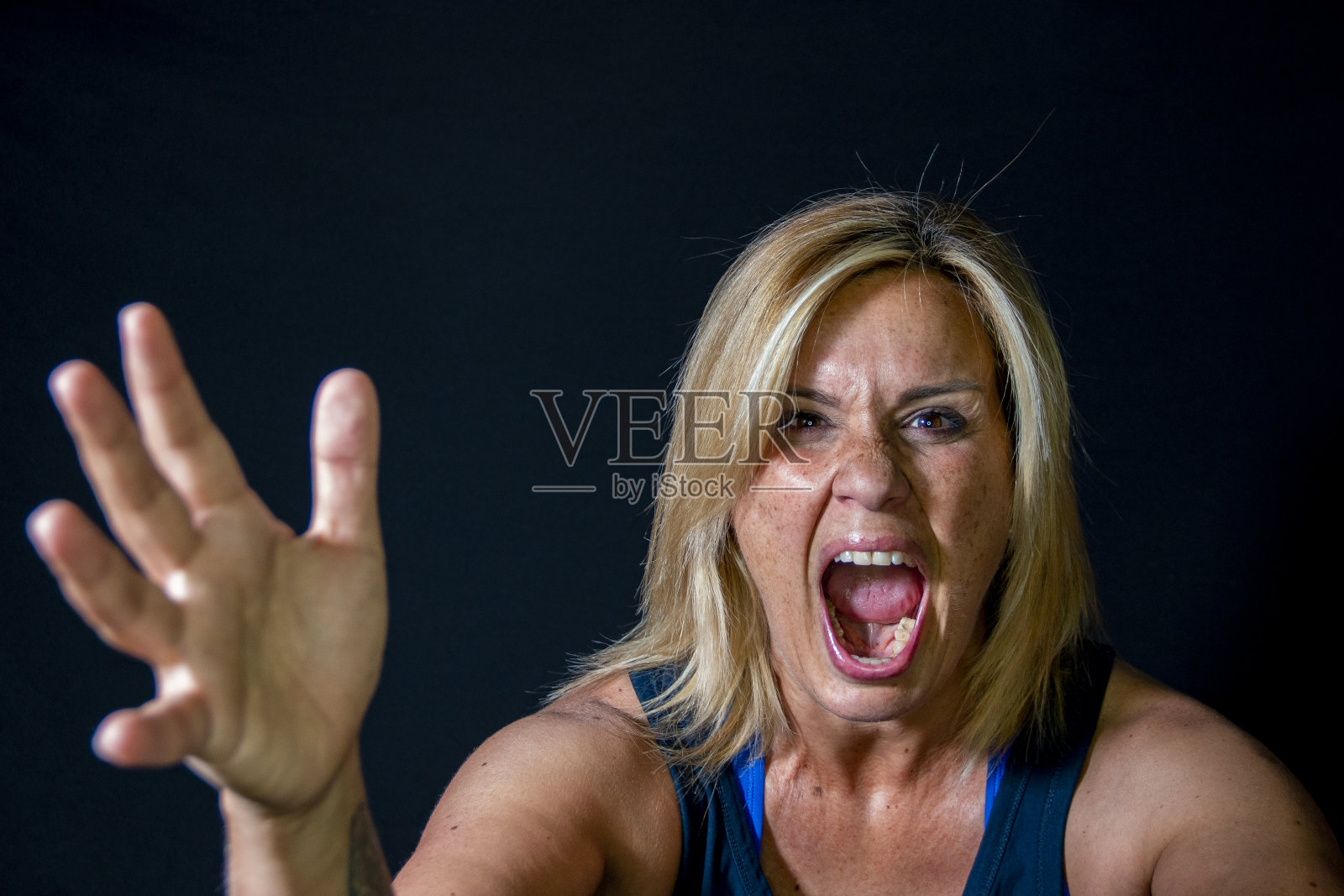 一个金发女人在黑色背景上用手做不同的手势照片摄影图片