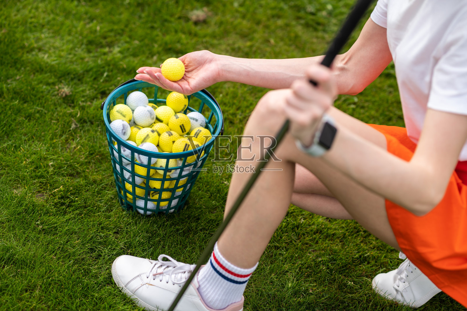 女子高尔夫球手在夏季绿地上拿着高尔夫球照片摄影图片