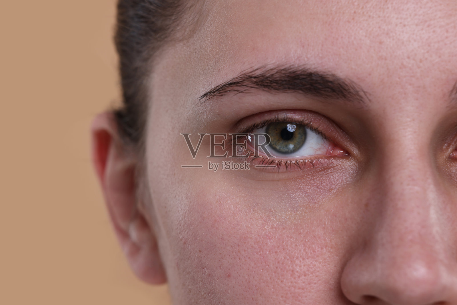 在米色背景上有着美丽的淡褐色眼睛的女人的特写照片摄影图片