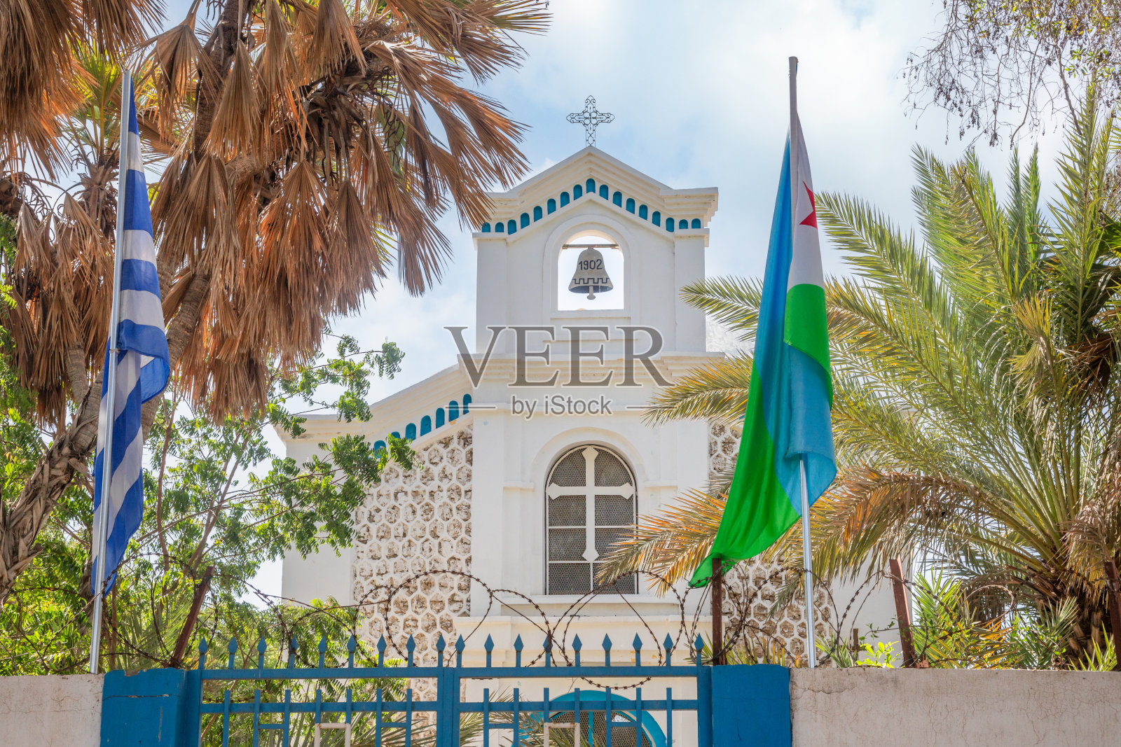 圣君士坦丁和海伦希腊东正教白色教堂,两侧各有棕榈树和旗帜,吉布提市,非洲之角照片摄影图片