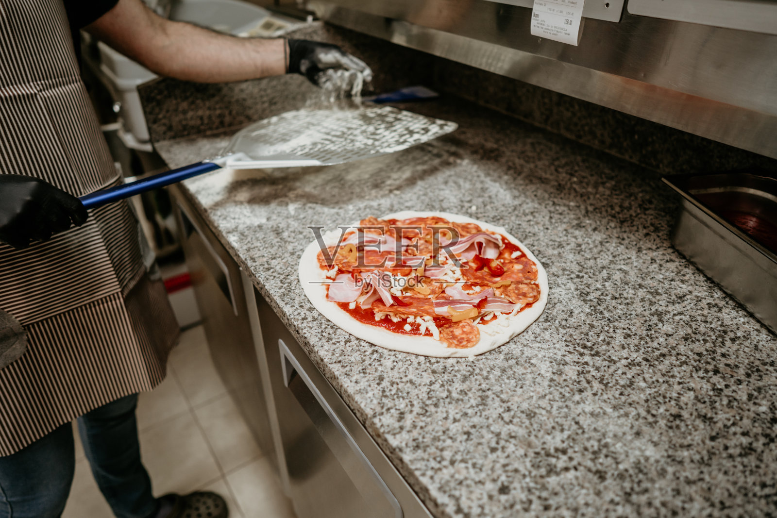 一个成年英俊的披萨面包师在做披萨照片摄影图片