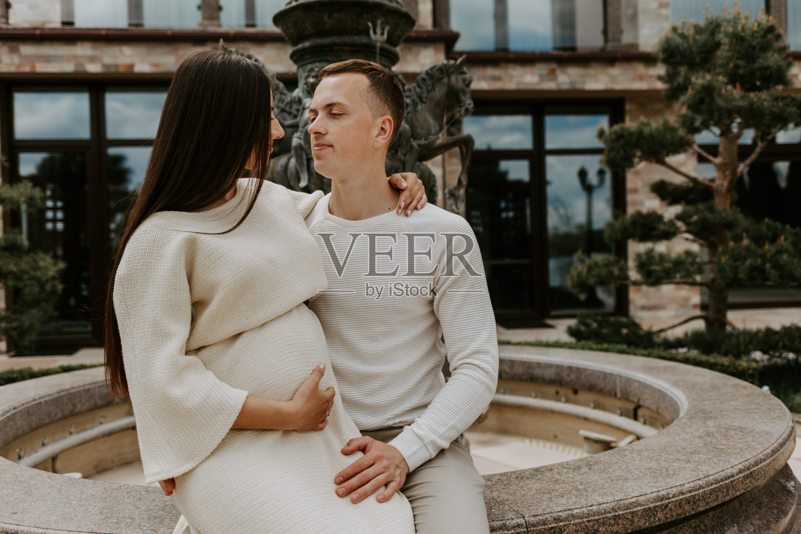 幸福的一对:一个年轻美丽的怀孕的妻子穿着长裙和丈夫一起走在一个阳光明媚的夏日。恋爱中的男人和女人。照片摄影图片