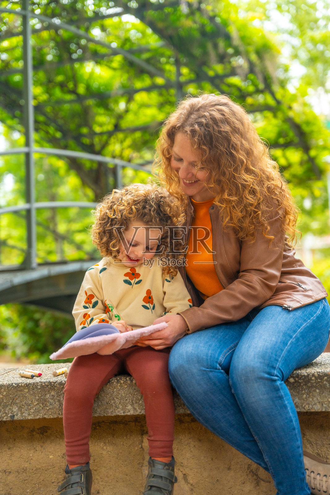 母女俩在公园里一起看书照片摄影图片