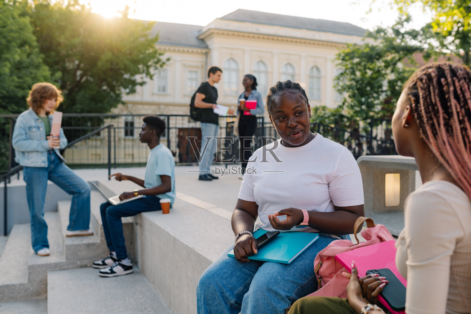 不同的女学生在学校的楼梯上和同学聊天照片摄影图片