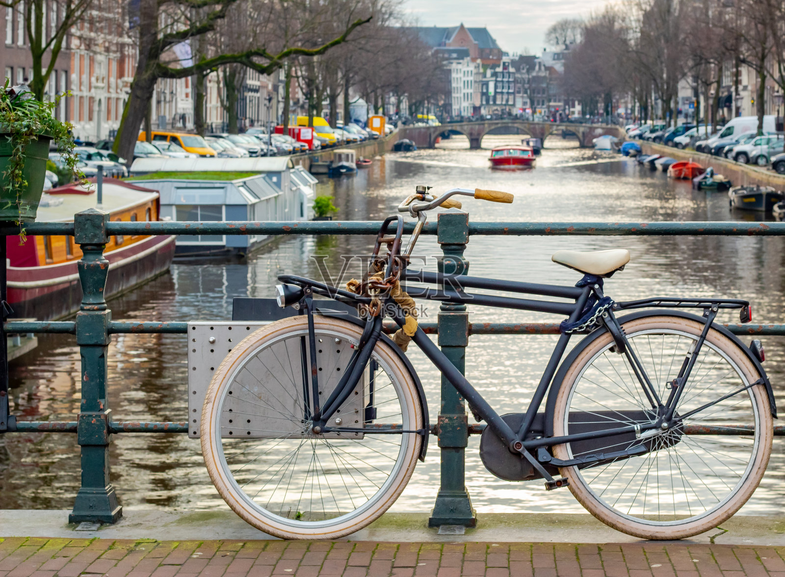 一辆自行车停在阿姆斯特丹运河两旁的建筑旁。照片摄影图片