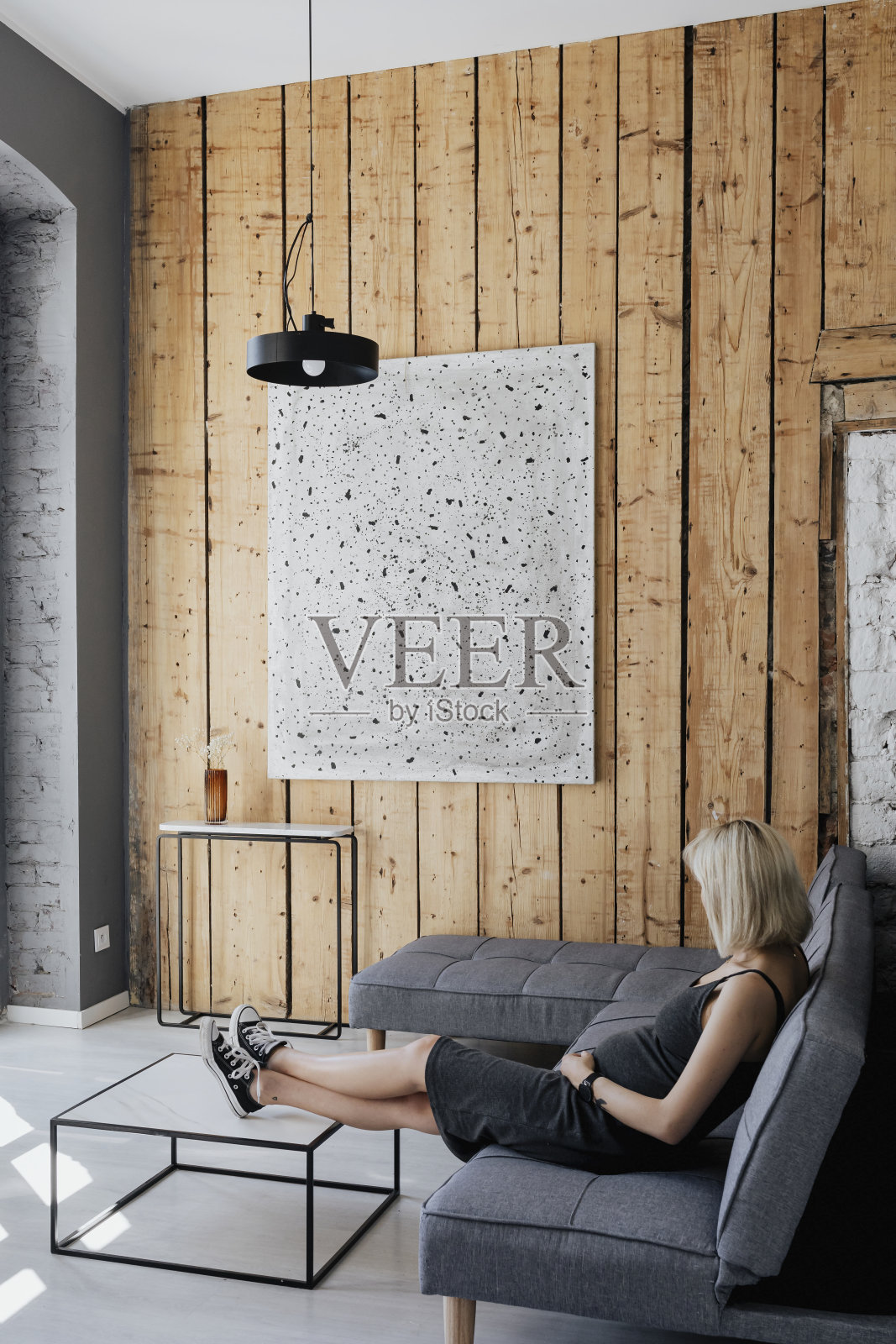 怀孕的金发女人在灰色的沙发上休息照片摄影图片