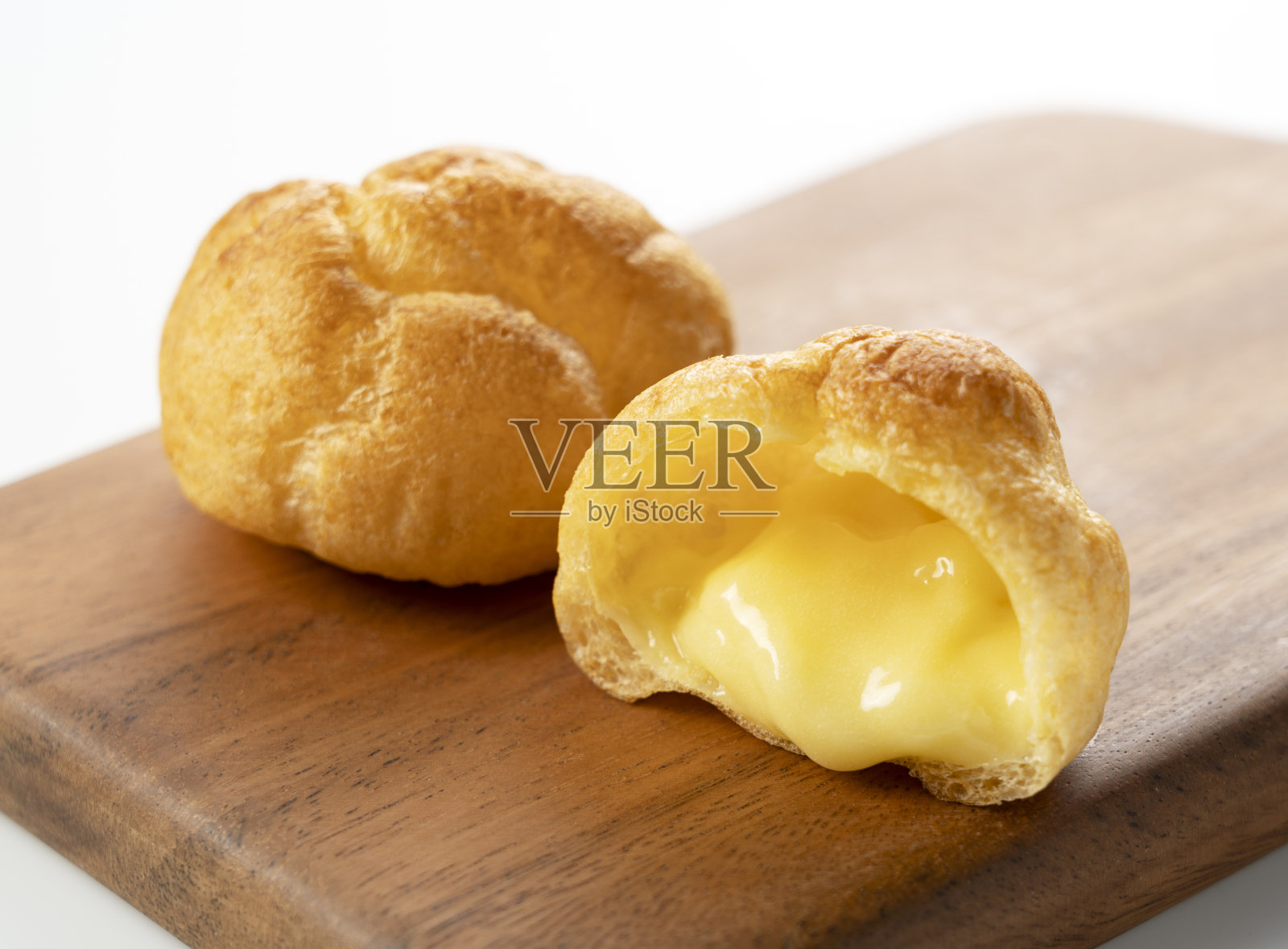 奶油泡芙放在白底的砧板上。照片摄影图片