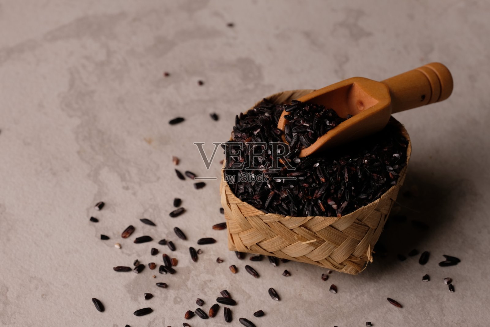 黑米装在竹编容器里。黑米是血糖指数低、纤维含量高的大米。照片摄影图片