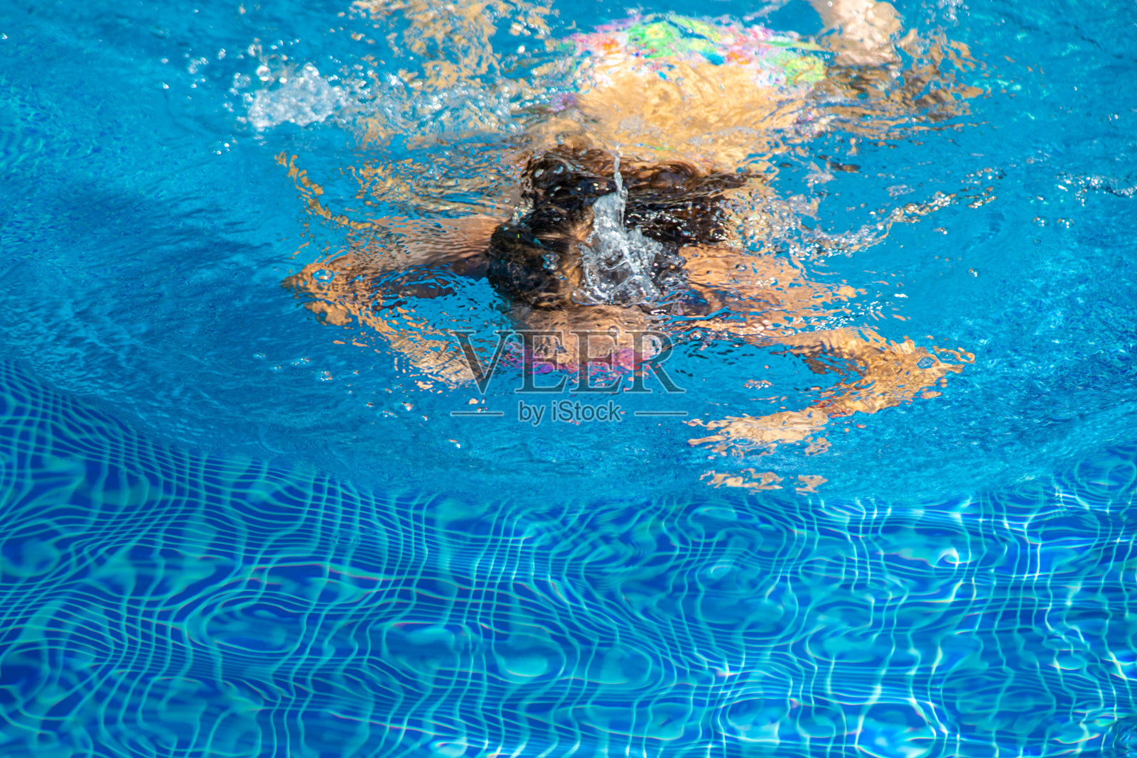 孩子在游泳池里跳水。有选择性的重点。照片摄影图片