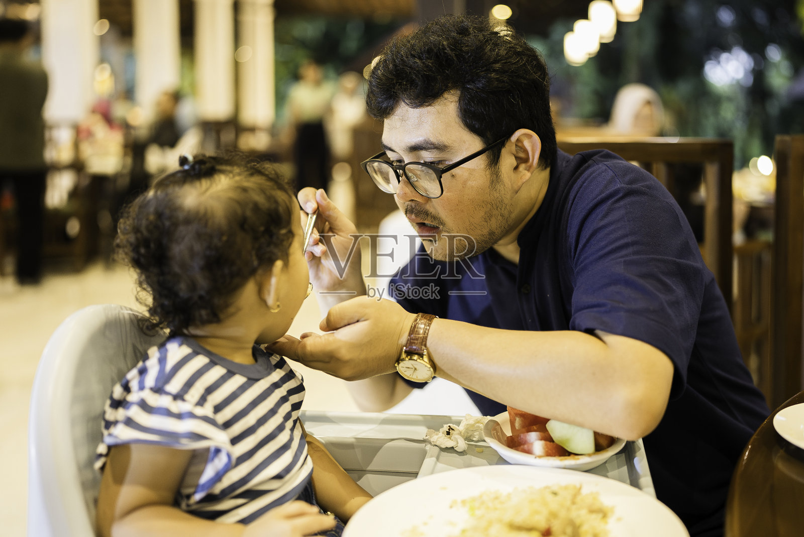 父亲给女儿喂奶照片摄影图片