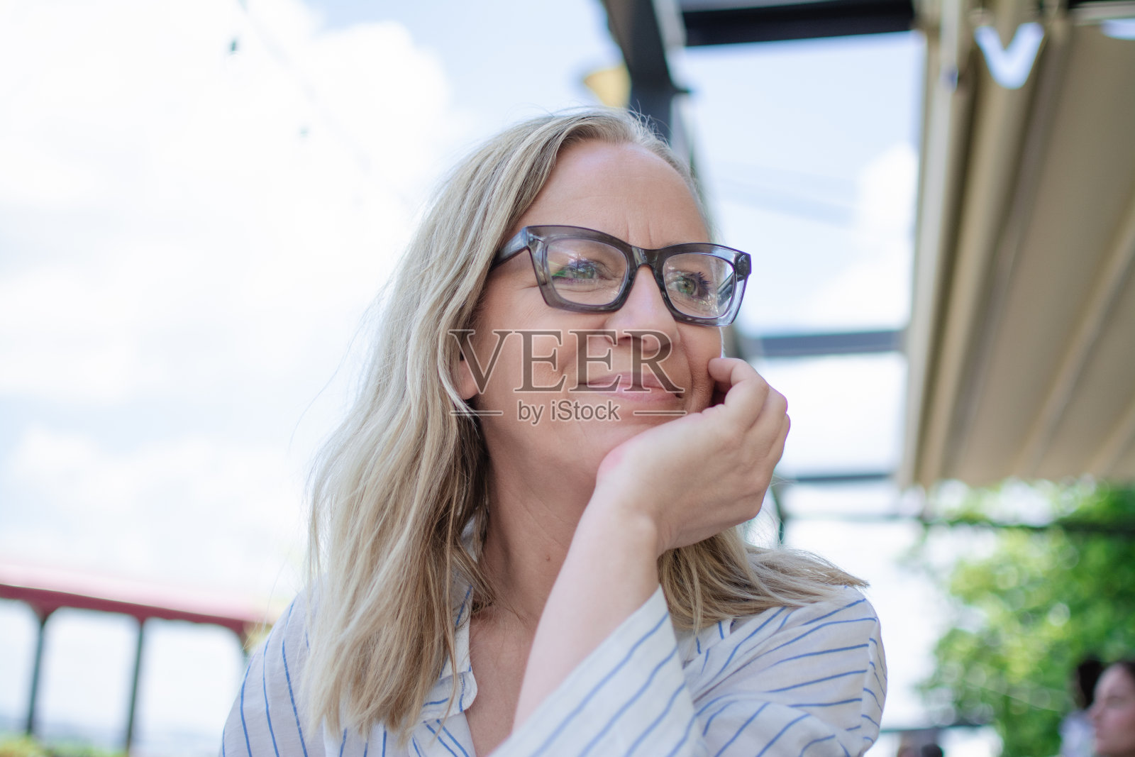 戴眼镜的快乐金发中年妇女肖像照片摄影图片