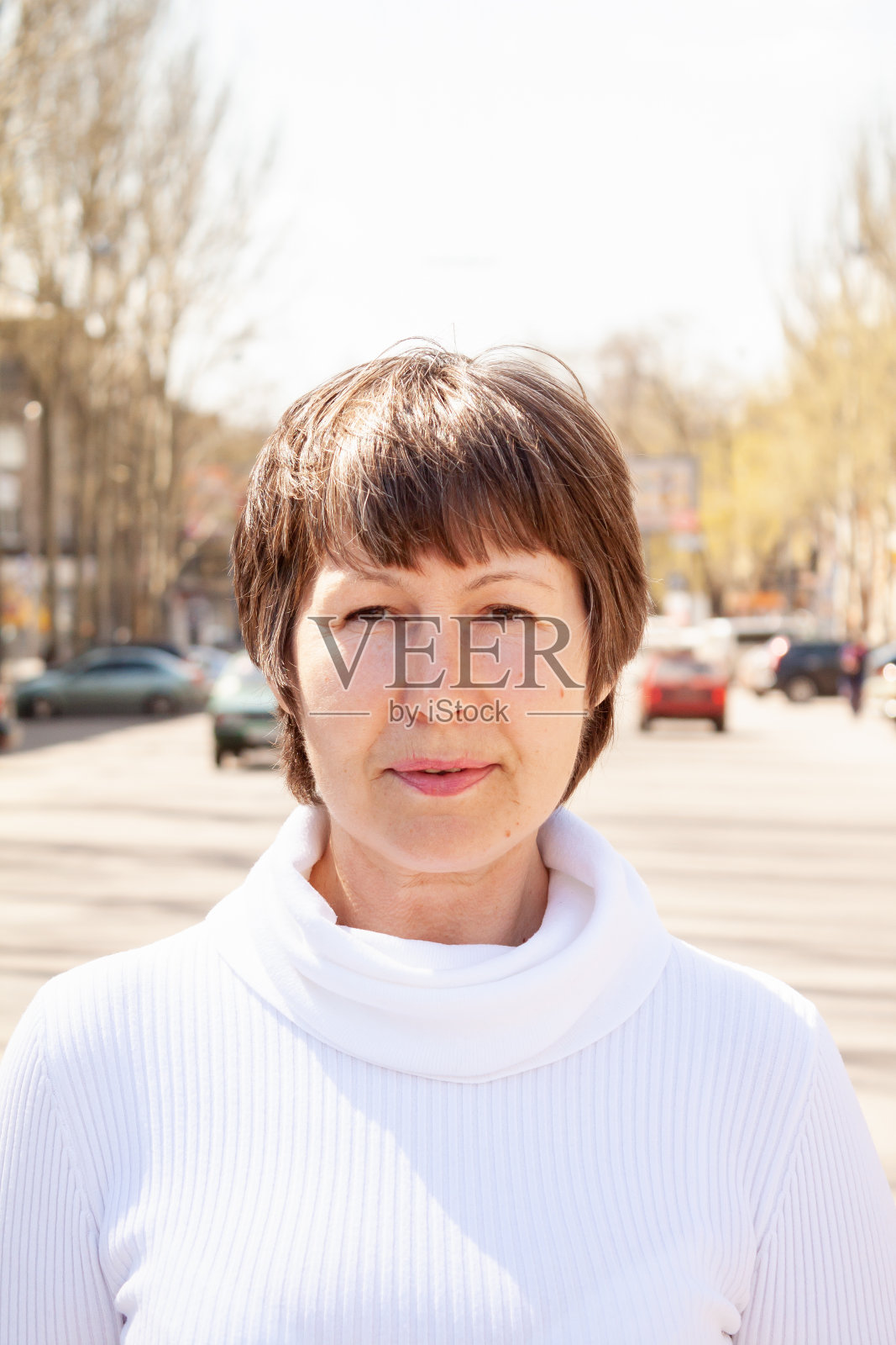 一个黑色短发的女人站在城市的街道上照片摄影图片