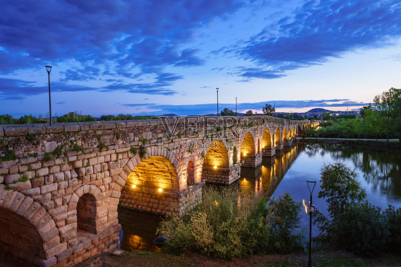 瓜迪亚纳河上的梅里达罗马桥在蓝色时刻被照亮照片摄影图片