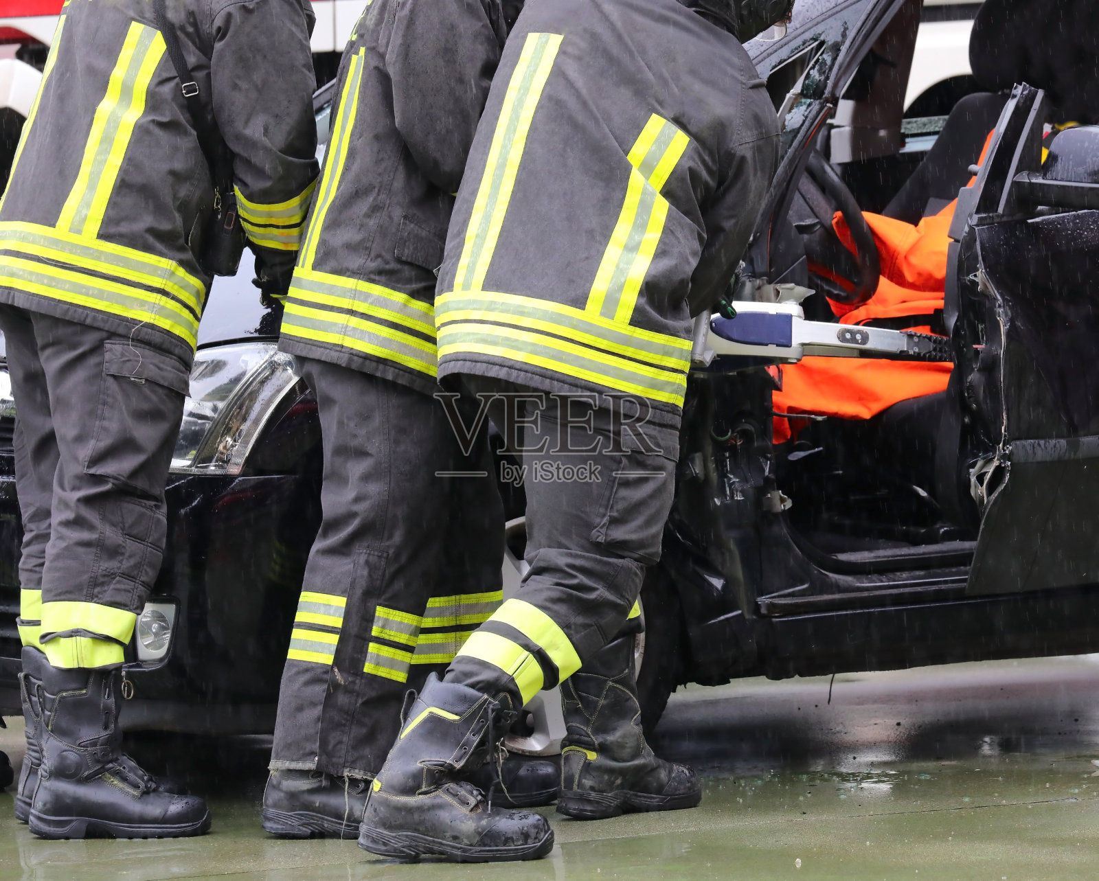 在一场交通事故后,消防队员用强大的液压剪切钳打开了受损汽车的车门照片摄影图片