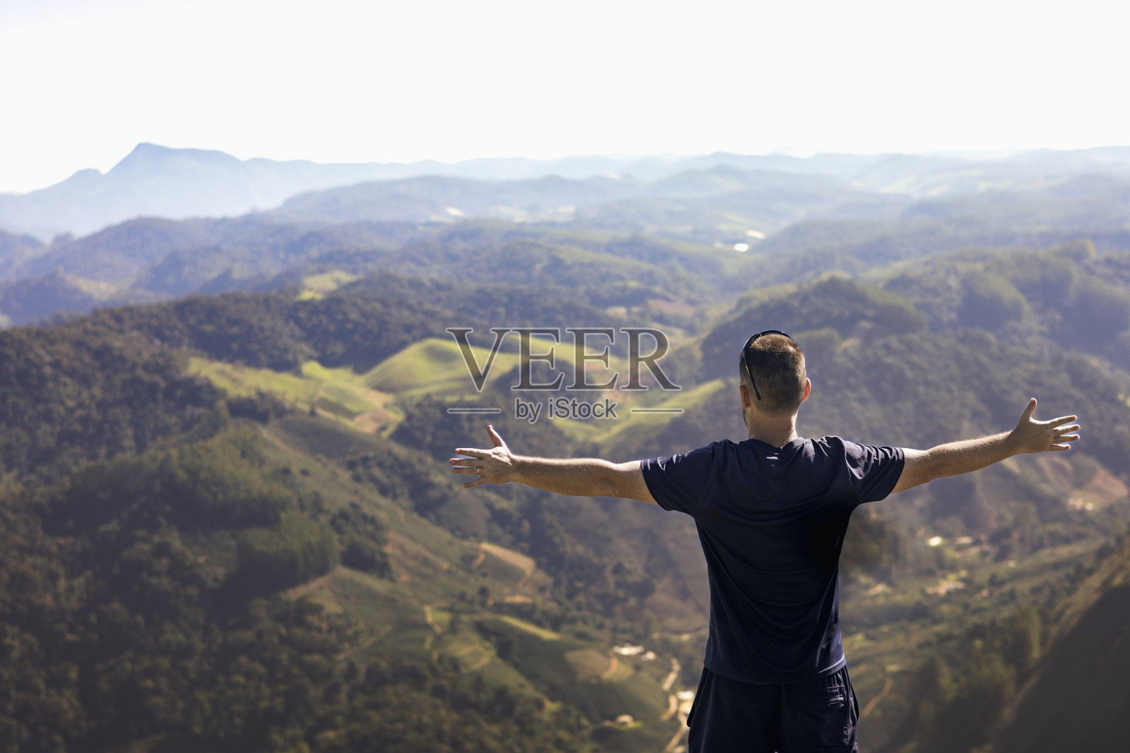 一个男人在大自然中享受安静的时刻,张开双臂站在那里。照片摄影图片