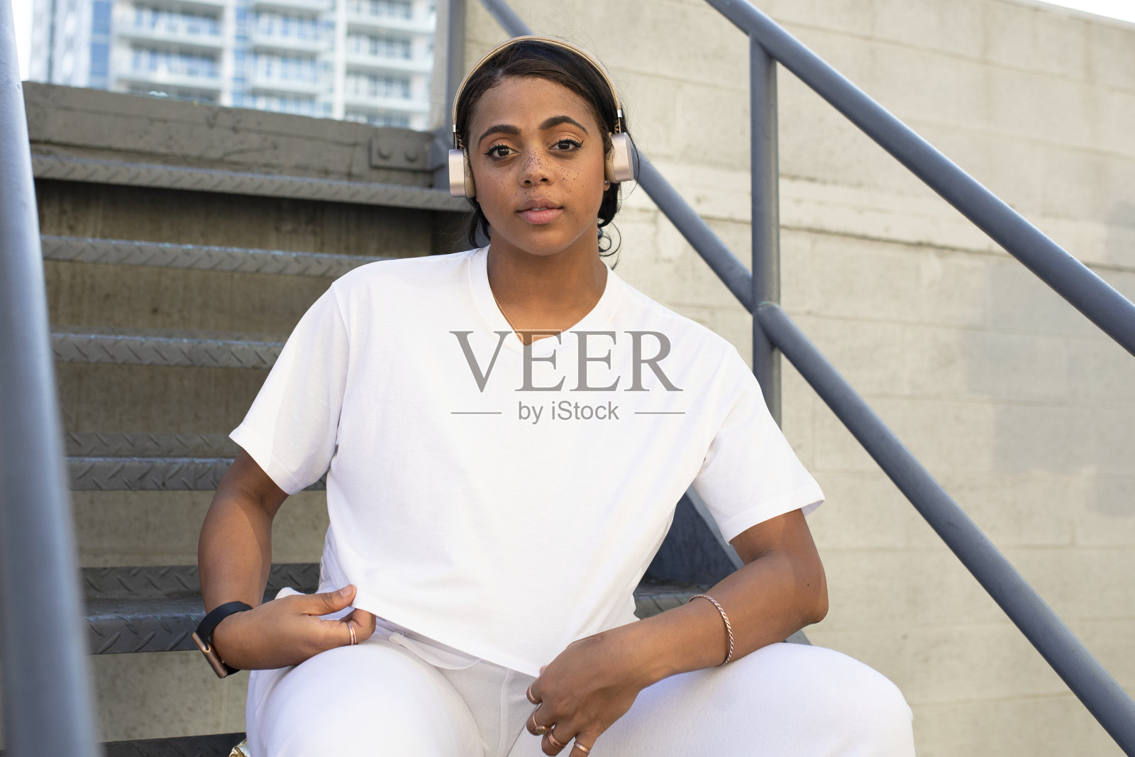 坐在楼梯上听音乐的酷女人照片摄影图片