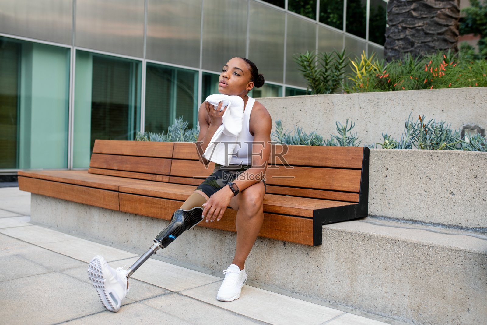 一名戴着义肢的妇女在锻炼后使用毛巾照片摄影图片