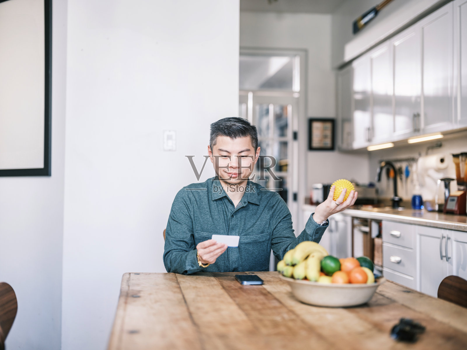 年轻的亚洲男子在家里检查他的健康保险卡照片摄影图片