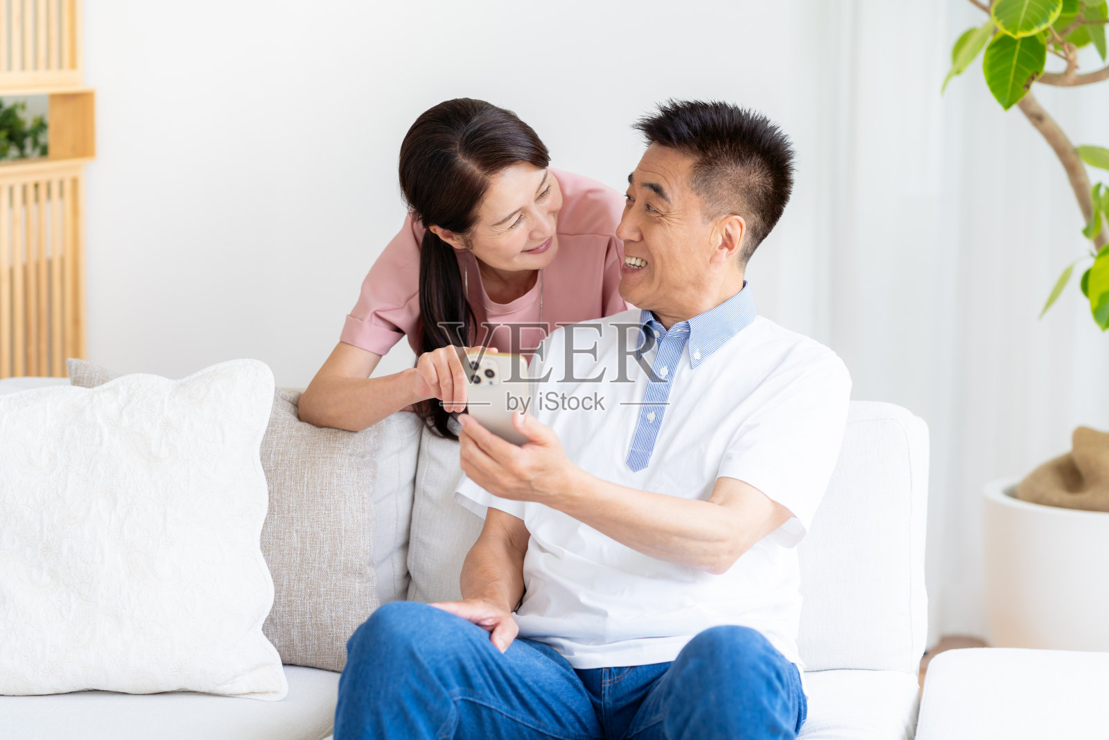 老夫妇在客厅看智能手机照片摄影图片