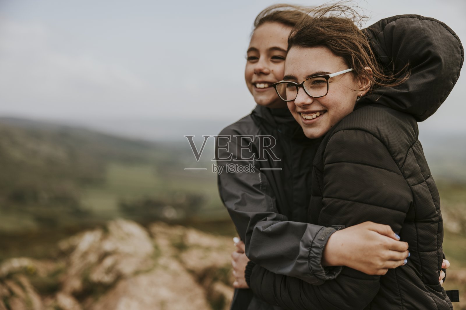 姐妹们在山上互相拥抱照片摄影图片