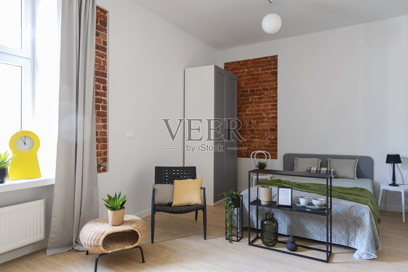 卧室工业内景:舒适的床、砖墙和木地板。新公寓的带窗房间。照片摄影图片