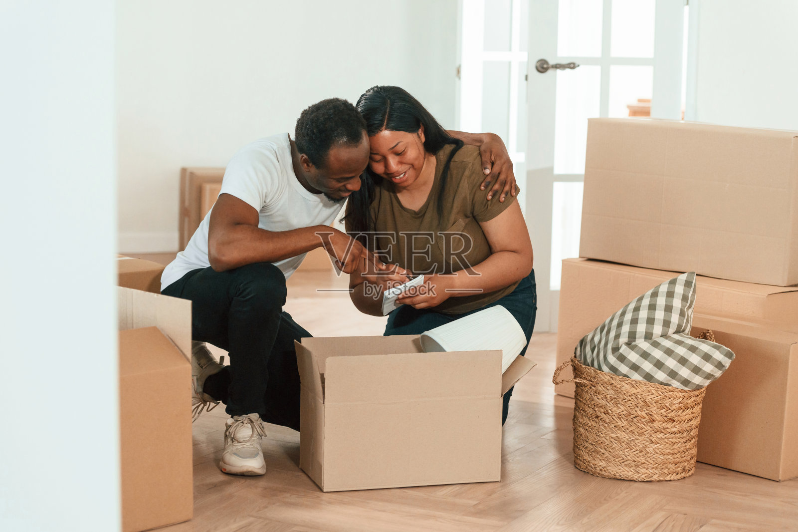 在记事本上做笔记。一对非裔美国夫妇要搬进新家了照片摄影图片