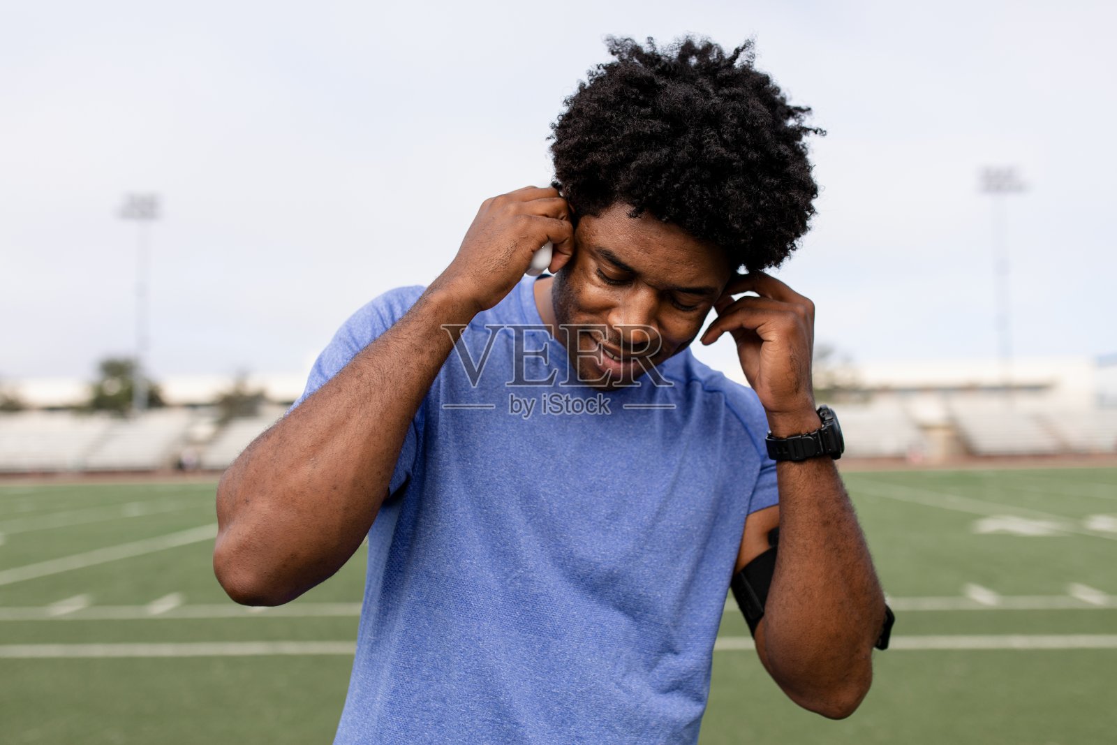 男运动员把耳机戴在耳朵上听音乐照片摄影图片