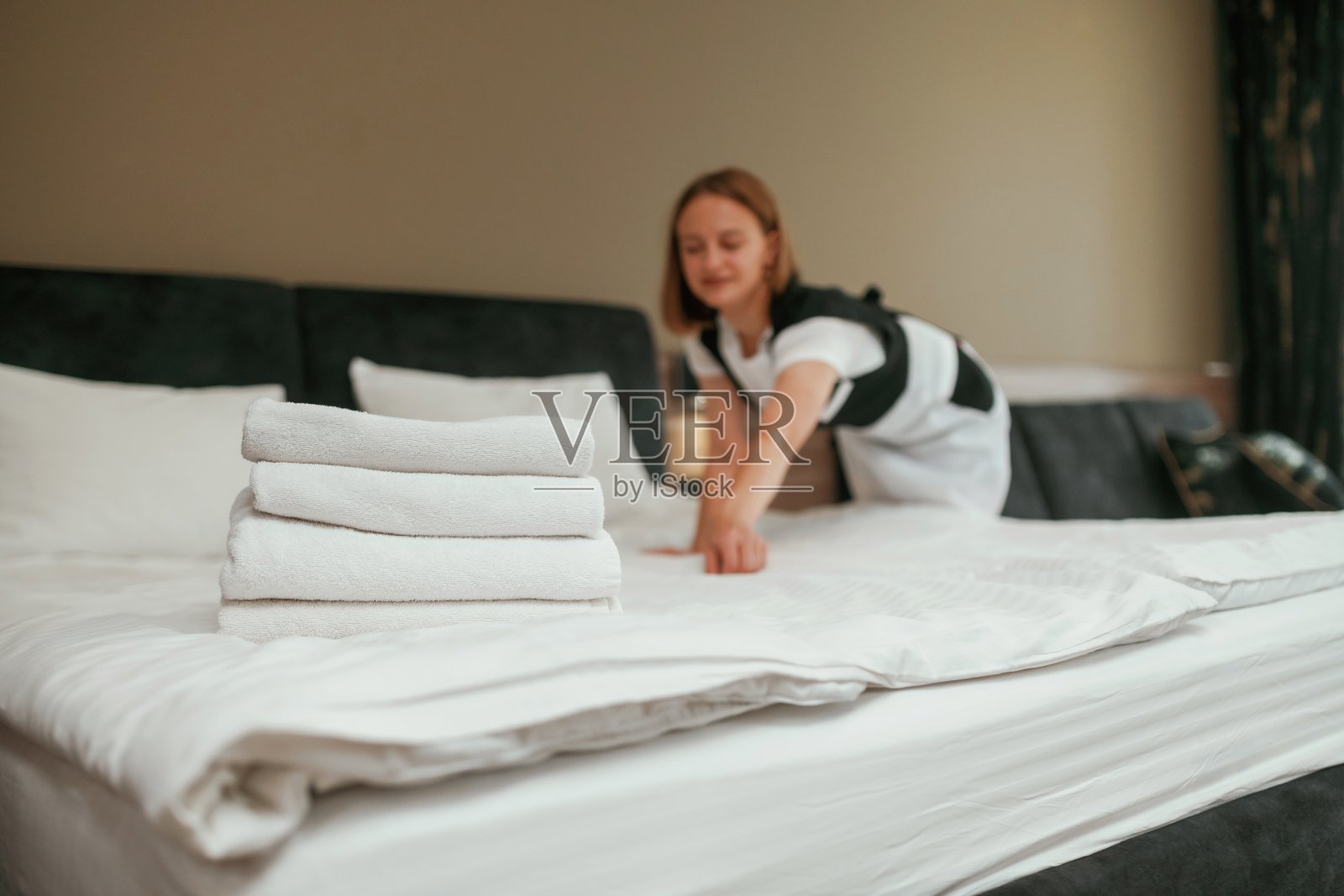 忙碌,工作和职业的概念。年轻的女服务员在旅馆房间里照片摄影图片