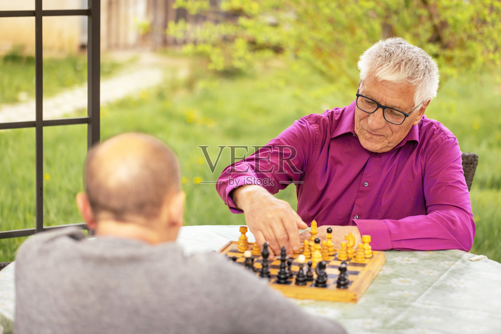 一位老人正在和他的朋友下棋照片摄影图片