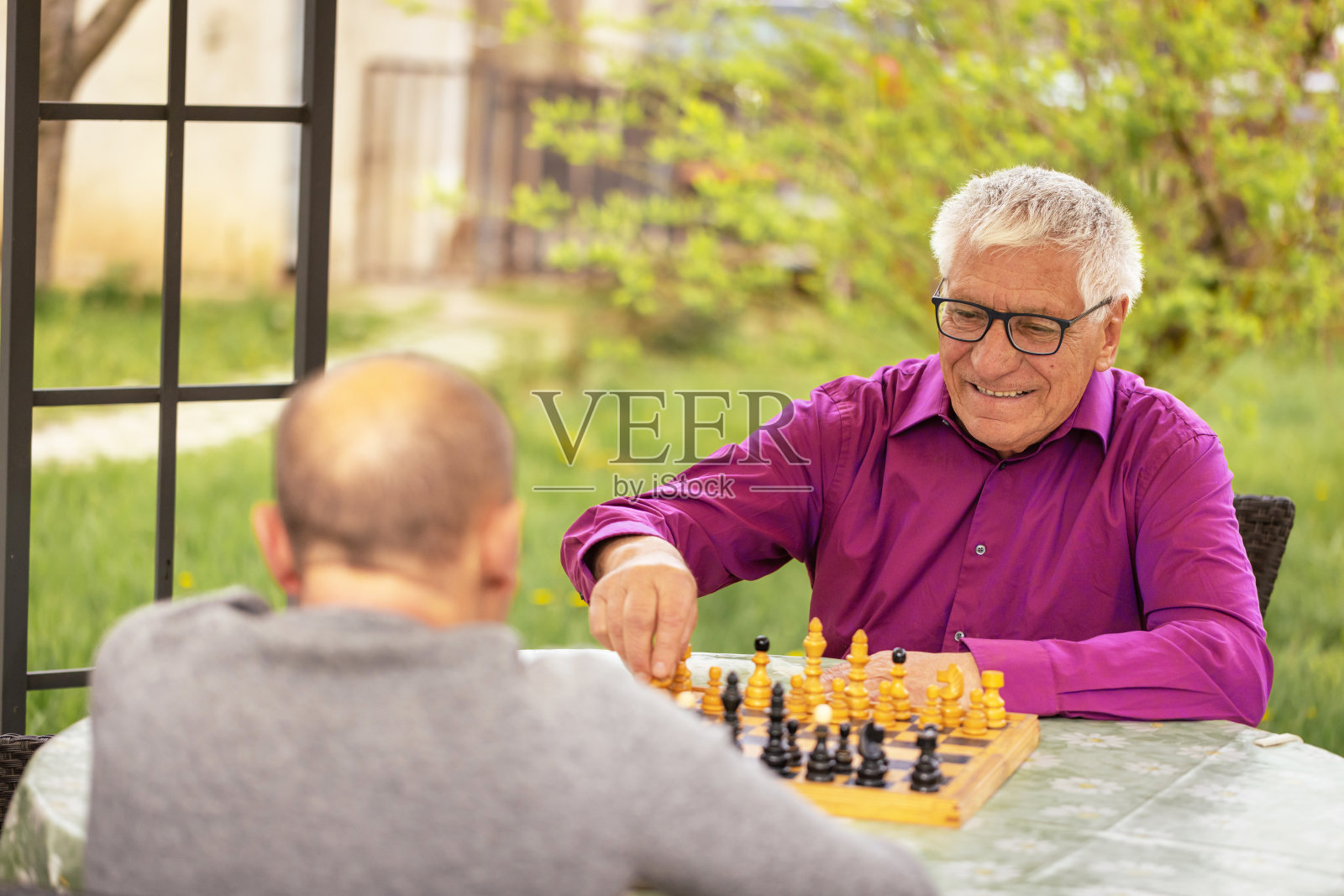 一位老人正在和他的朋友下棋照片摄影图片