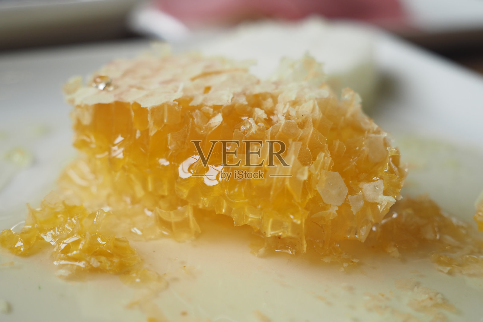 在一个罐子里用滤器对新鲜蜂蜜进行近距离拍摄照片摄影图片