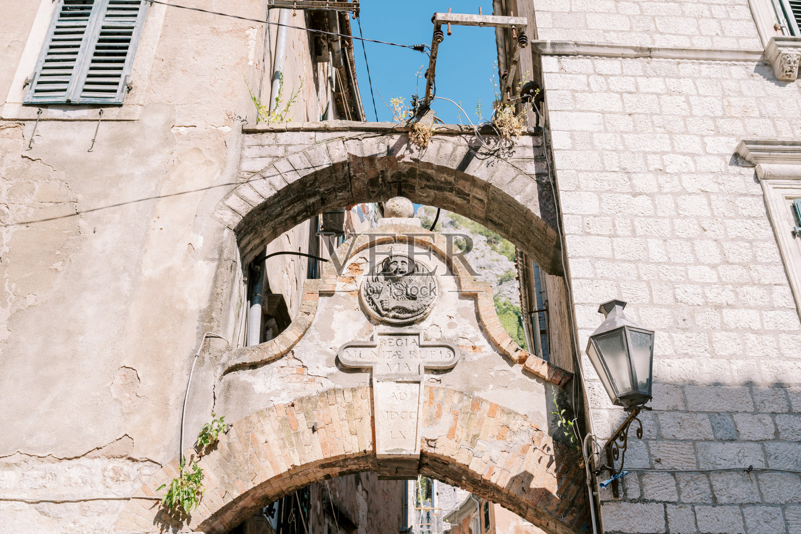 古代房屋之间拱门下的古代石质纹章。旧共和国武士,黑山照片摄影图片