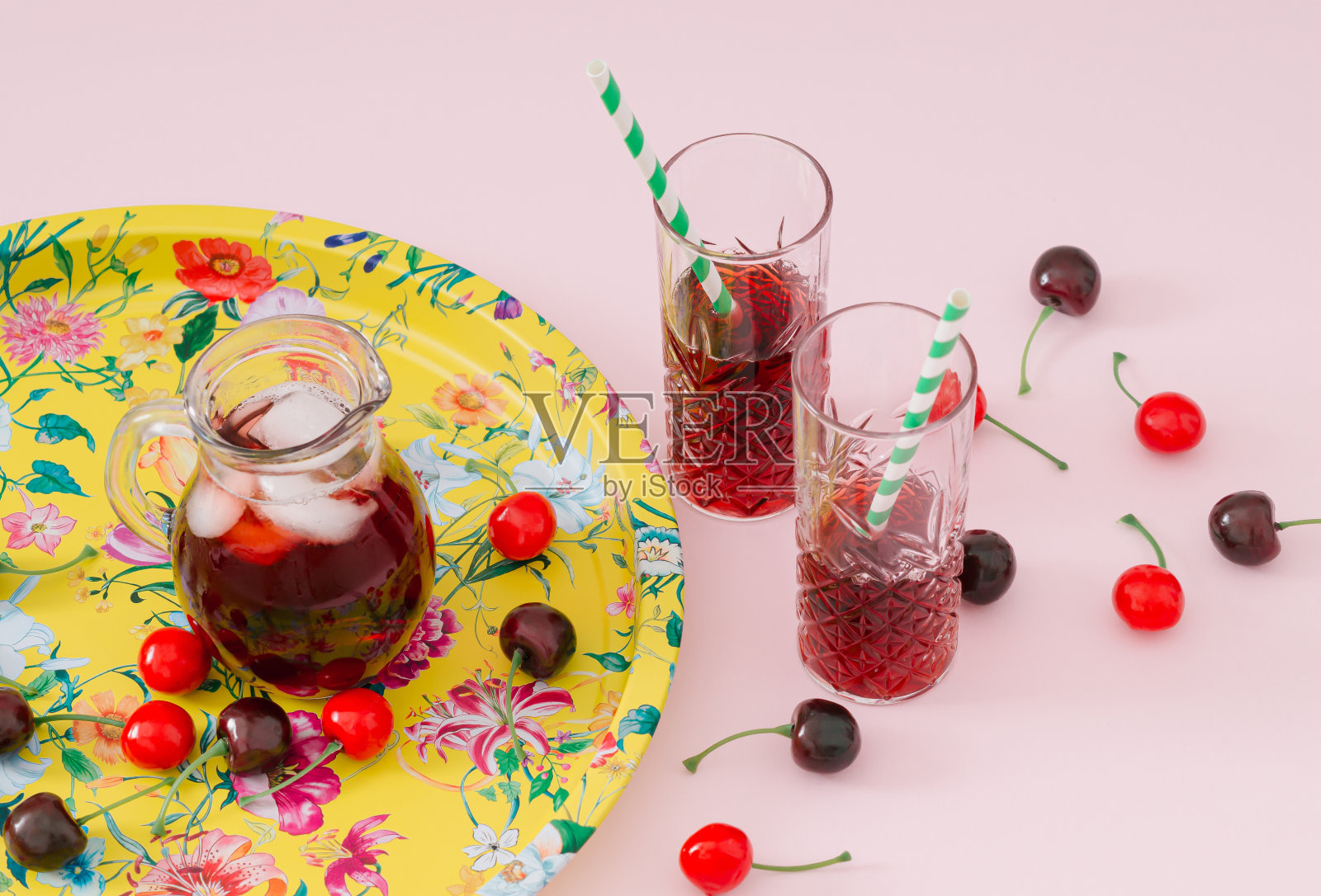 夏天的场景由清凉的樱桃汁和红色的樱桃在粉红色的背景。夏日水果饮品概念。时髦的夏日派对点子。复古美学的时尚风格。照片摄影图片