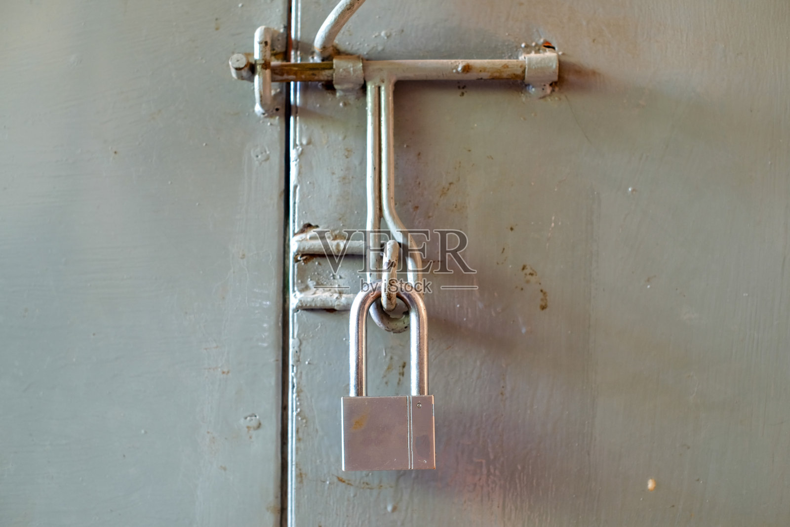 安全不锈钢挂锁的大门上的小灰色集装箱关闭。高质量照片照片摄影图片