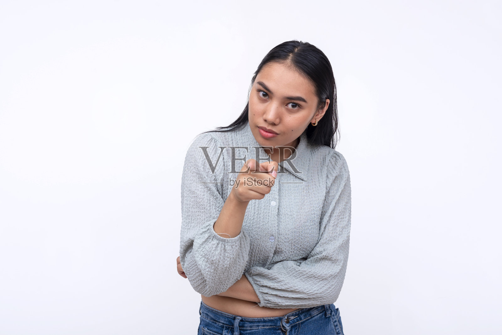 一个可疑的年轻亚洲女人提出指控。指着镜头,责怪某人。孤立在白色背景上。照片摄影图片