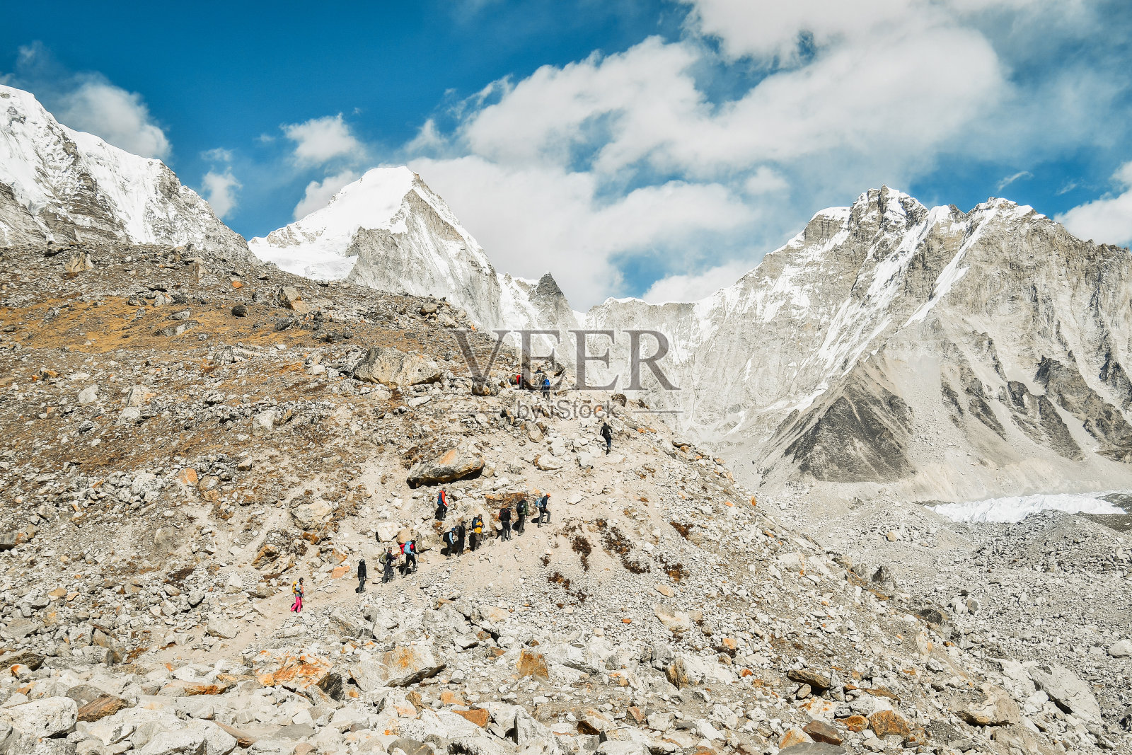 在夏尔巴向导的带领下,一群徒步旅行者在萨加马塔国家公园徒步旅行,最后到达EBC观景台。EBC徒步旅行。珠峰大本营在秋天徒步旅行,秋天天气晴朗。照片摄影图片