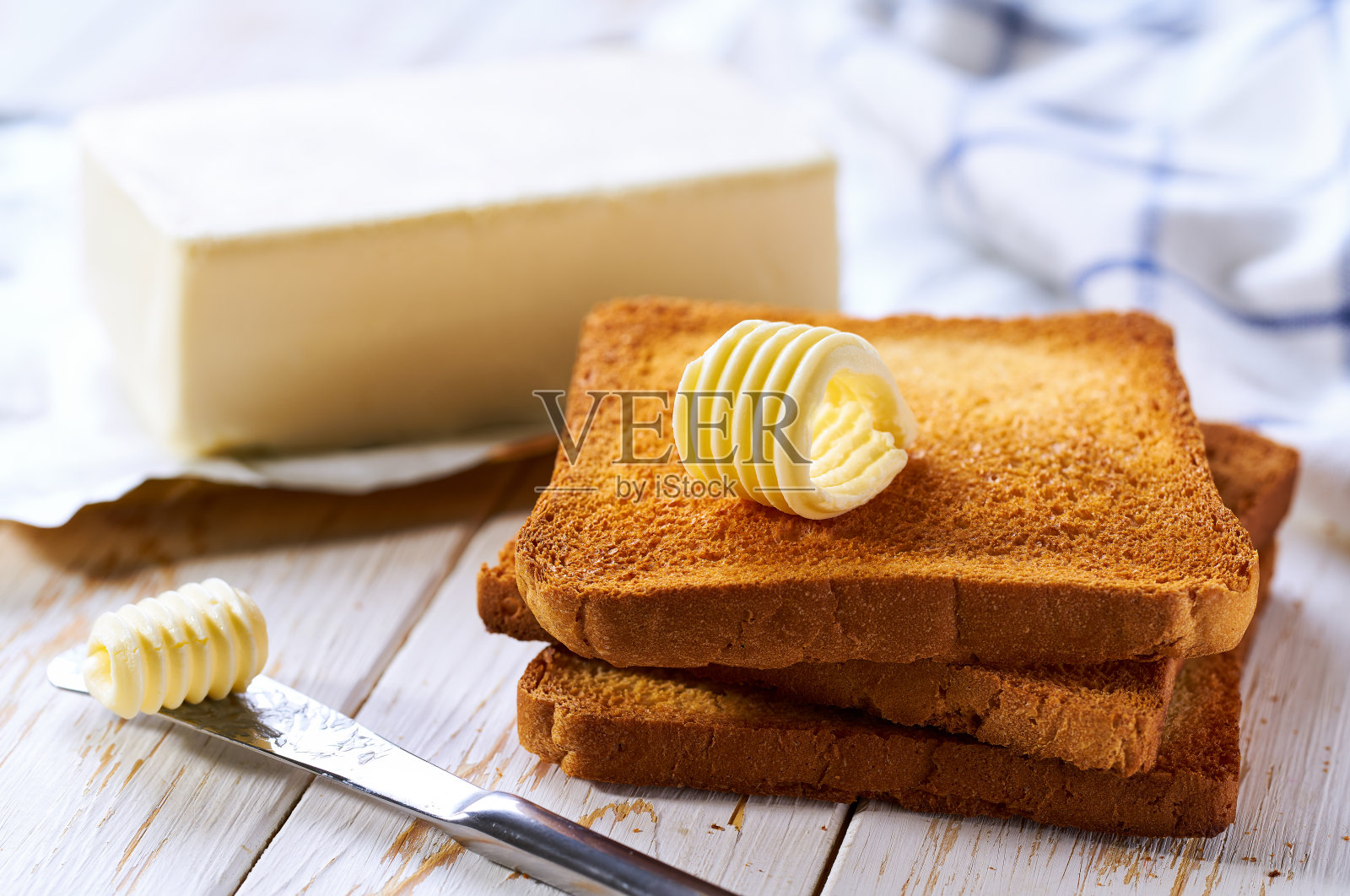 烤面包和新鲜的黄油卷在木桌上。照片摄影图片