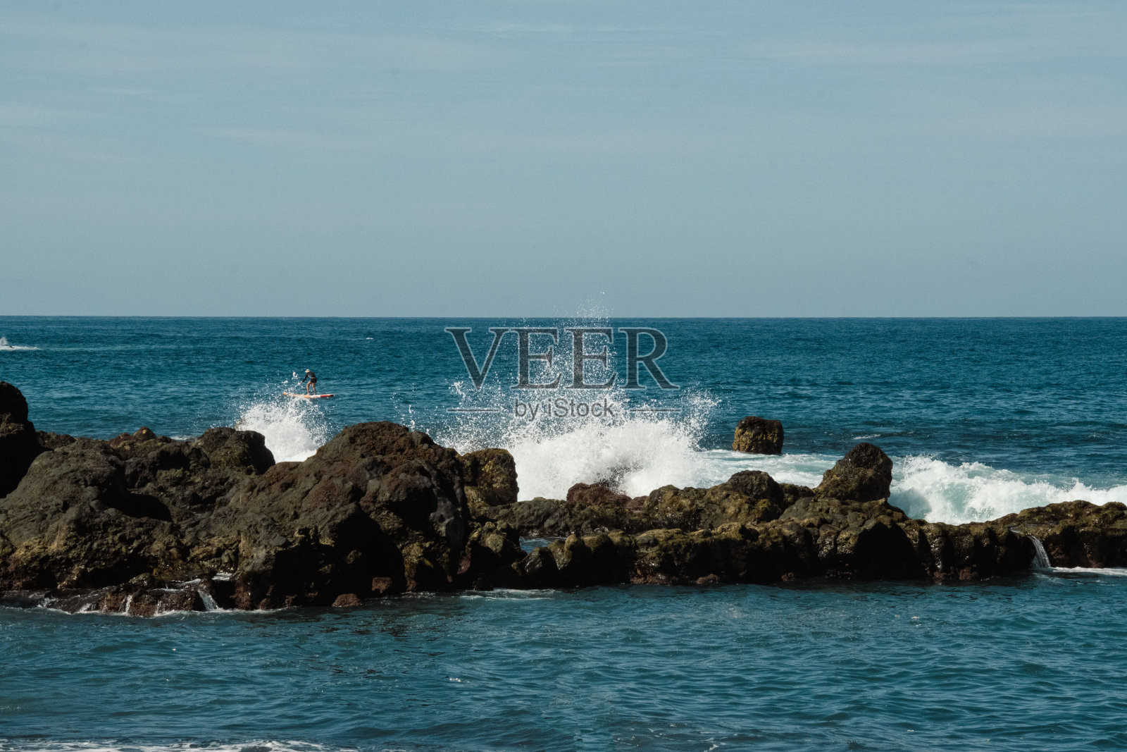 有黑色火山岩和海浪的岩石海滩。美丽的海岸照片摄影图片