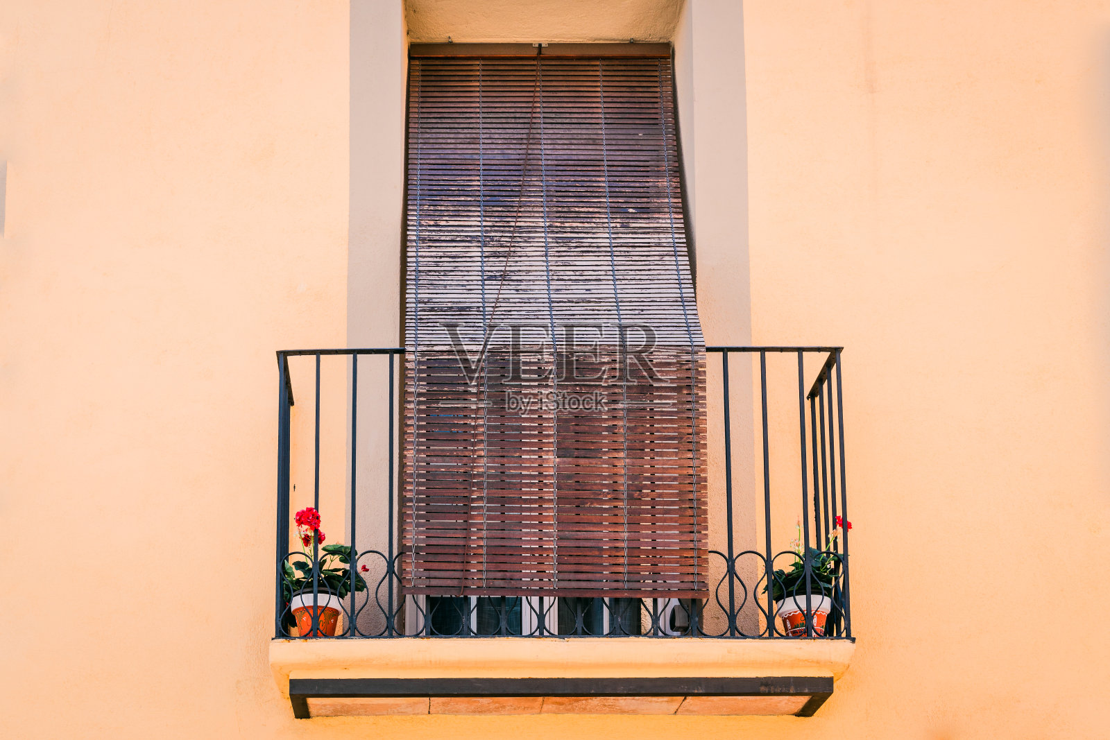 一个传统的阳台唤起地中海风格的温暖,装饰着植物和百叶窗。照片摄影图片